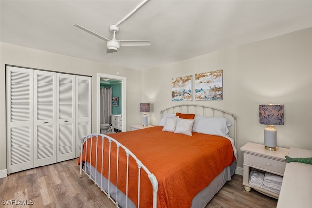 bedroom featuring a closet, ceiling fan, ensuite bath, wood finished floors, and baseboards