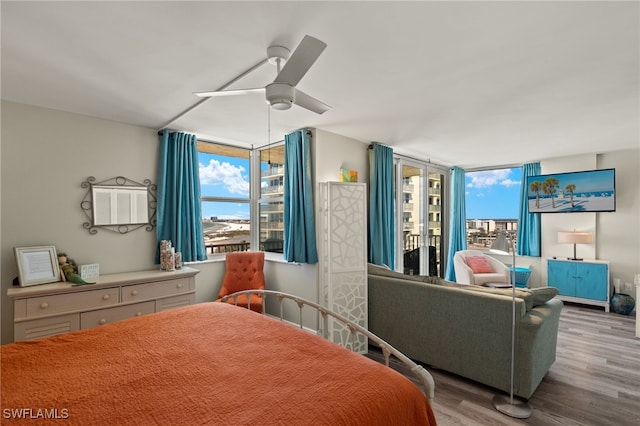 bedroom with multiple windows, a ceiling fan, and wood finished floors