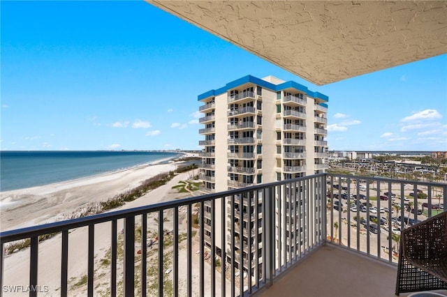 balcony featuring a beach view and a water view