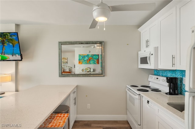 kitchen with white appliances, baseboards, white cabinets, wood finished floors, and light countertops