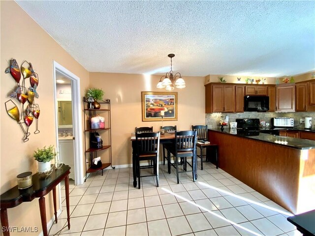 kitchen with pendant lighting, light tile patterned floors, decorative backsplash, and black appliances