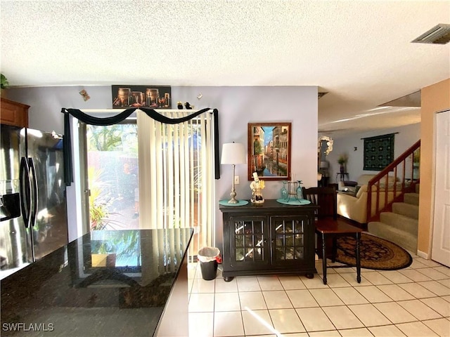 interior space featuring light tile patterned floors and a textured ceiling