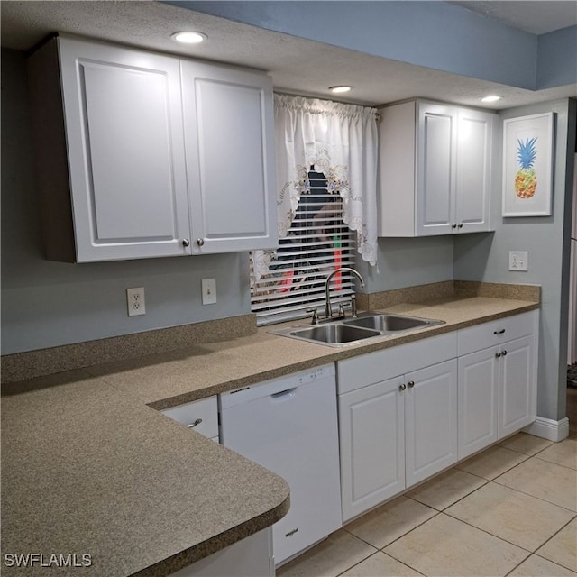 kitchen featuring white dishwasher, recessed lighting, white cabinets, a sink, and light tile patterned floors