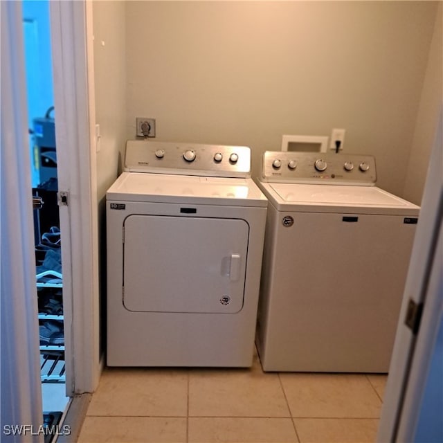 laundry area with light tile patterned floors, laundry area, and washing machine and dryer