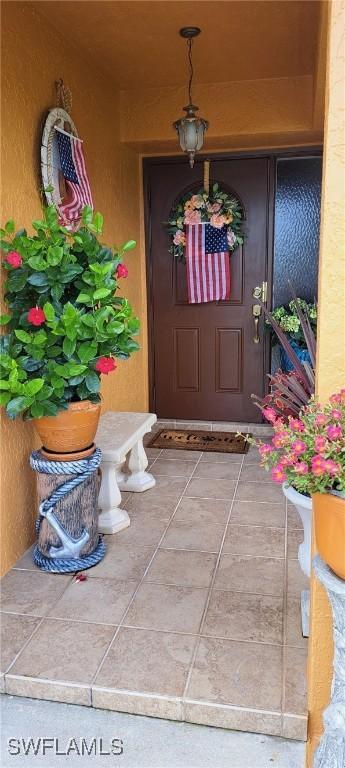 property entrance featuring covered porch and stucco siding