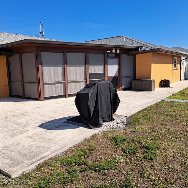 back of property with a patio, roof with shingles, and stucco siding