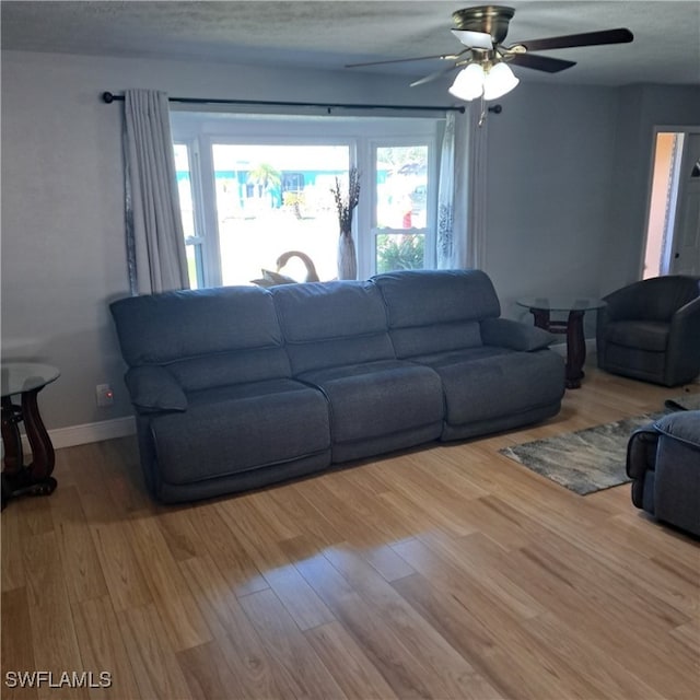 living room with ceiling fan, hardwood / wood-style floors, and a textured ceiling