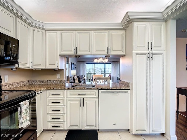 kitchen with light tile patterned flooring, dark stone countertops, kitchen peninsula, and black appliances