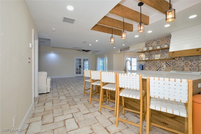 kitchen with sink, decorative light fixtures, a breakfast bar area, and ceiling fan