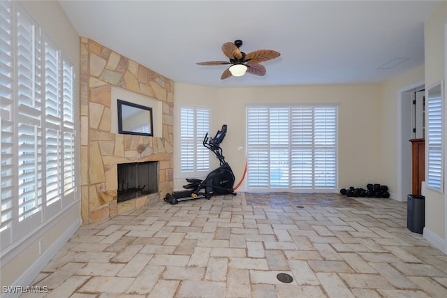 exercise area featuring a fireplace and ceiling fan