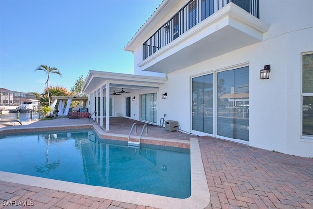 view of swimming pool with ceiling fan, a pergola, and a patio