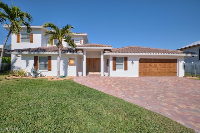 mediterranean / spanish-style house featuring a garage and a front lawn