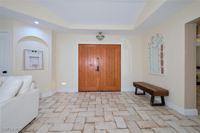 foyer entrance with a tray ceiling