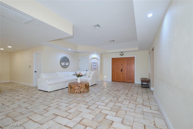 unfurnished living room featuring a tray ceiling