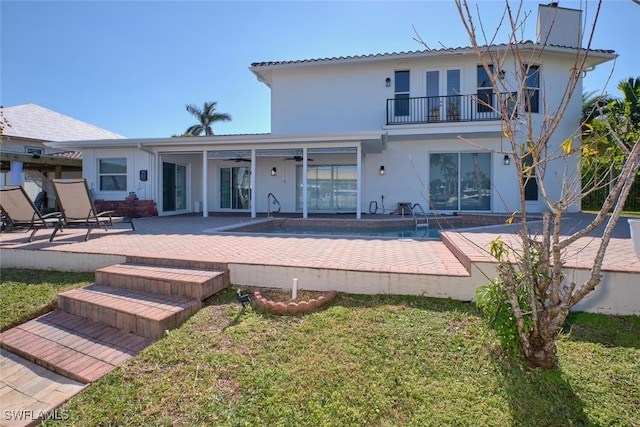 back of house featuring a yard, a patio area, and a balcony