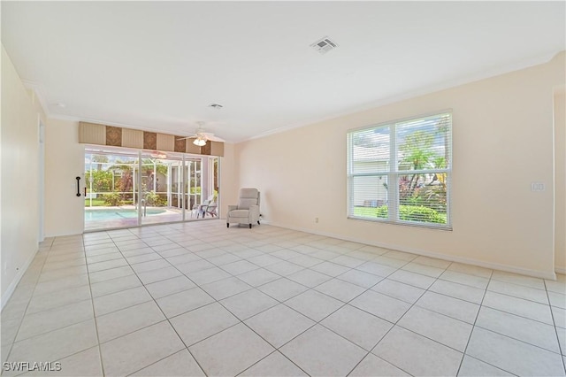 tiled spare room featuring crown molding, plenty of natural light, and ceiling fan