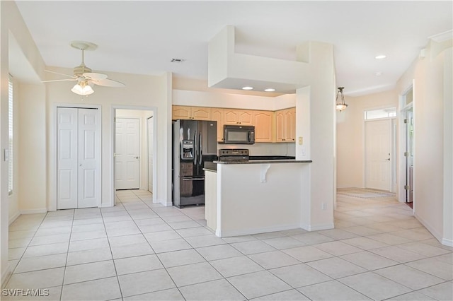 kitchen featuring light brown cabinetry, black appliances, light tile patterned floors, ceiling fan, and kitchen peninsula