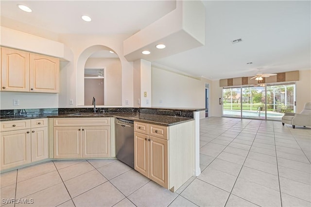 kitchen featuring light tile patterned floors, sink, dishwasher, kitchen peninsula, and dark stone counters