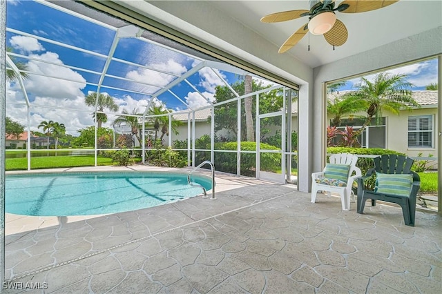 view of pool featuring a patio, ceiling fan, and glass enclosure