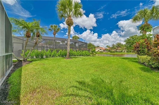 view of yard featuring a lanai and a water view