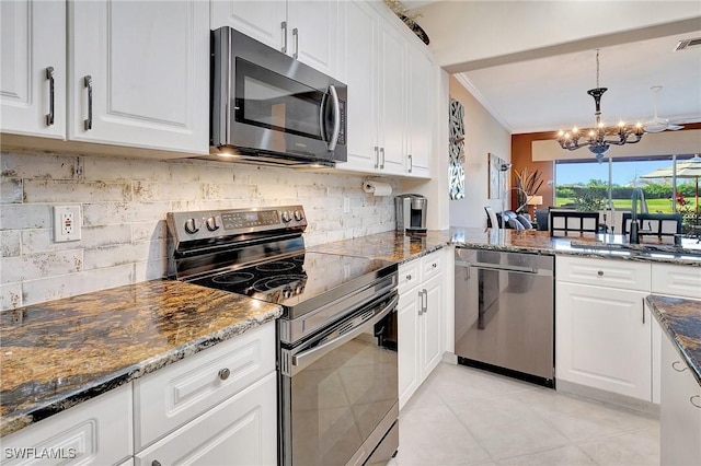 kitchen with stainless steel appliances, white cabinets, and dark stone counters