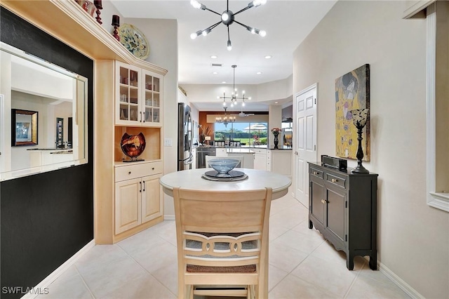 kitchen featuring light tile patterned flooring, a center island, a chandelier, stainless steel refrigerator, and pendant lighting