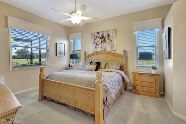 bedroom featuring light carpet, multiple windows, and ceiling fan