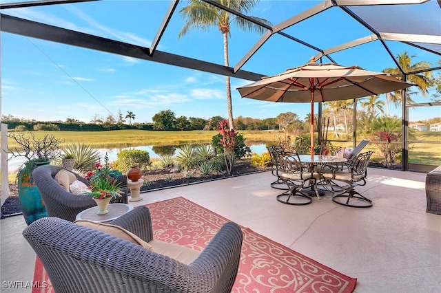 view of patio featuring glass enclosure and a water view