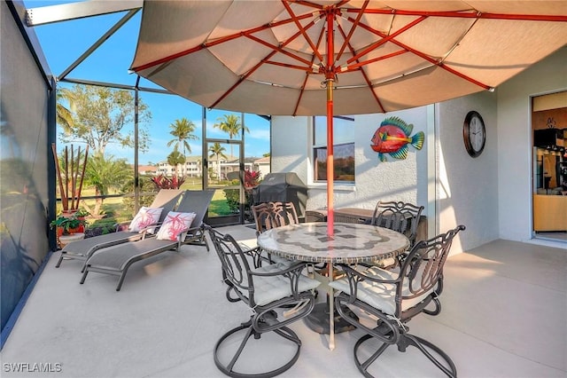 view of patio / terrace with grilling area and glass enclosure