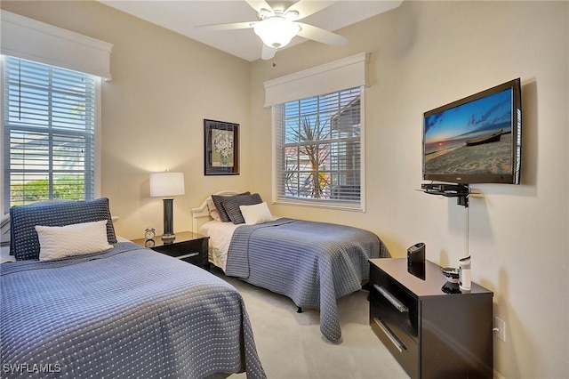 carpeted bedroom with ceiling fan and multiple windows