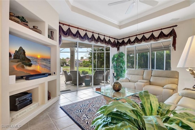 sunroom with ceiling fan and a tray ceiling