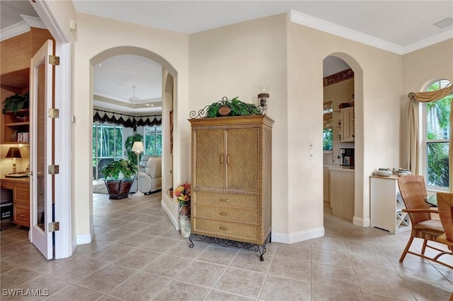 hall featuring light tile patterned flooring and crown molding