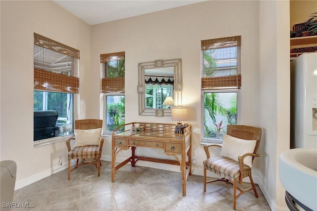 living area with light tile patterned flooring, sink, and a wealth of natural light