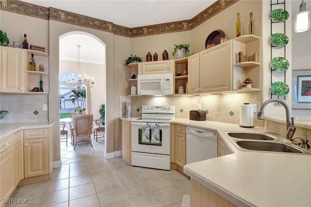 kitchen featuring an inviting chandelier, white appliances, sink, and hanging light fixtures