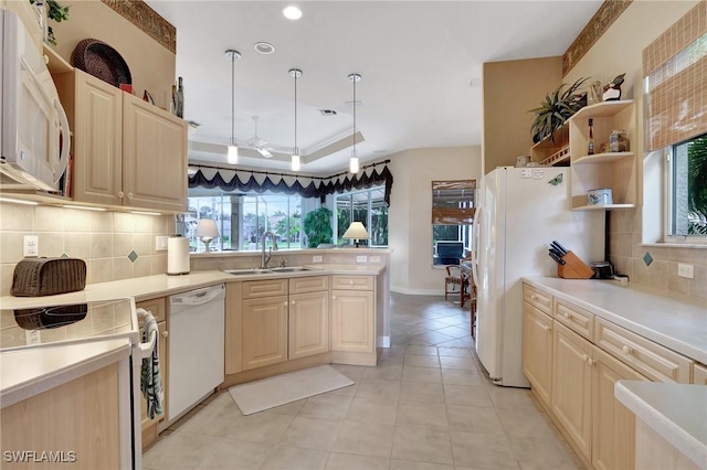 kitchen featuring sink, decorative light fixtures, a raised ceiling, white appliances, and backsplash