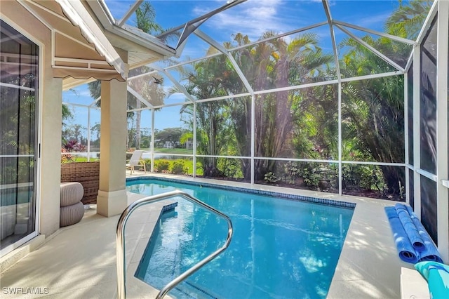 view of pool with a patio area and glass enclosure