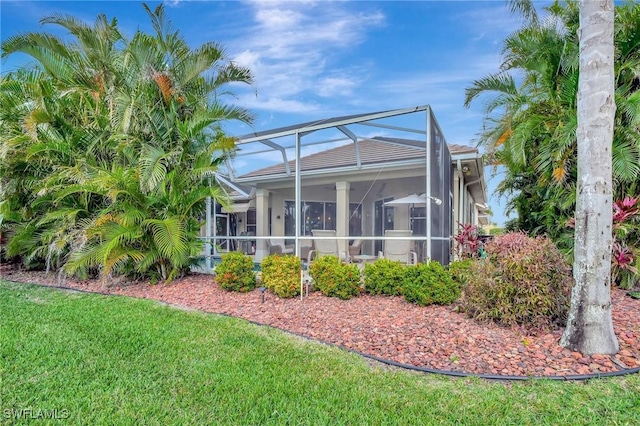 back of property with a yard and a lanai