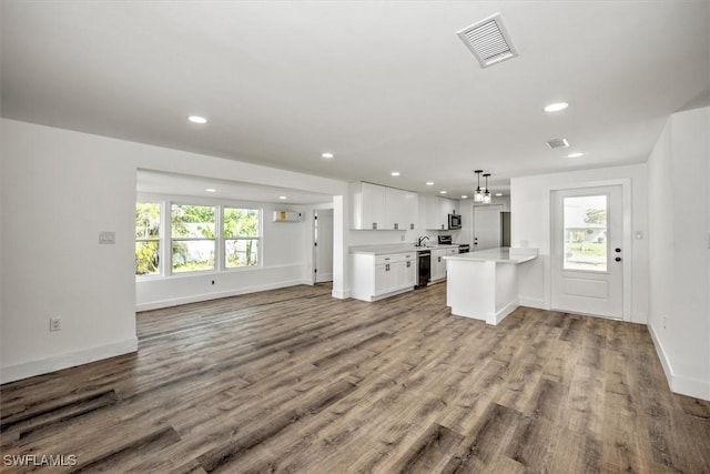kitchen featuring light countertops, stainless steel microwave, open floor plan, visible vents, and dishwasher