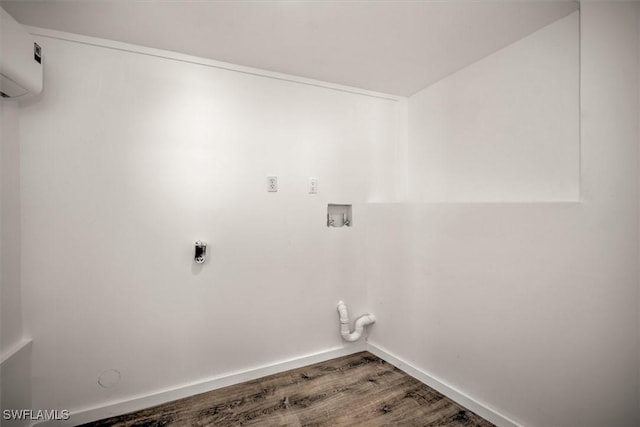 laundry room featuring a wall unit AC, hookup for a washing machine, laundry area, wood finished floors, and baseboards