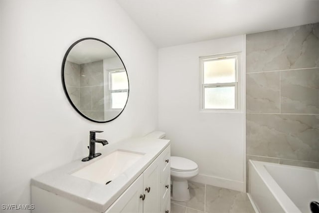 bathroom with marble finish floor, toilet, a bathing tub, vanity, and baseboards