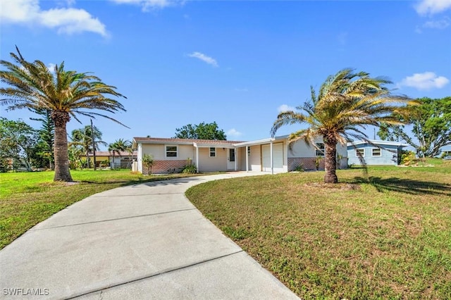 ranch-style home with concrete driveway, brick siding, and a front lawn