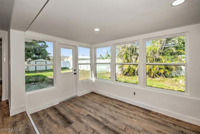 unfurnished sunroom with baseboards, wood finished floors, and recessed lighting
