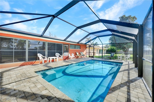 view of swimming pool featuring glass enclosure and a patio area