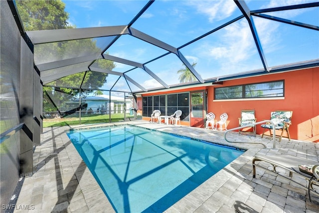 view of swimming pool featuring a patio and glass enclosure