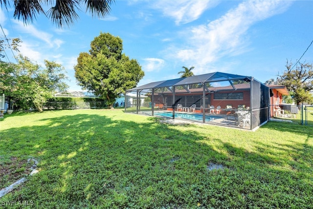 view of yard with a fenced in pool and glass enclosure