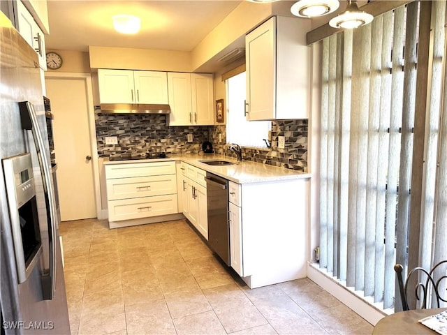 kitchen with sink, light tile patterned floors, appliances with stainless steel finishes, white cabinets, and backsplash