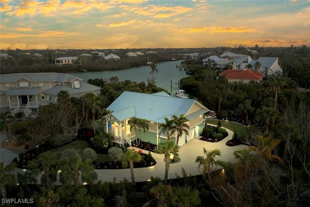 aerial view at dusk featuring a water view