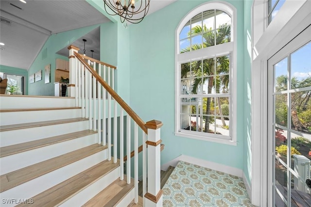 stairs featuring an inviting chandelier