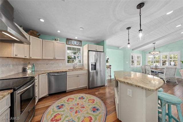 kitchen featuring decorative light fixtures, a kitchen island, exhaust hood, sink, and appliances with stainless steel finishes