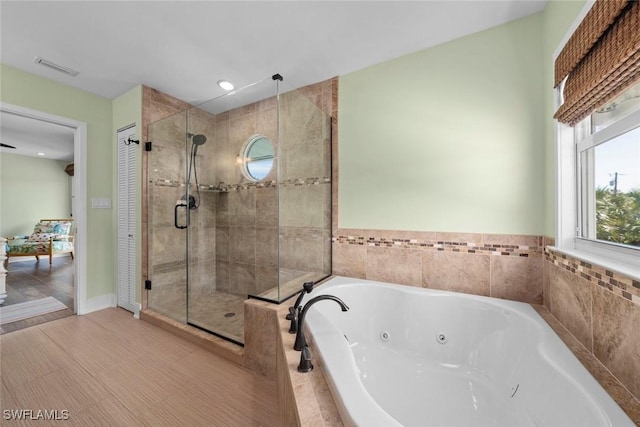 bathroom featuring separate shower and tub